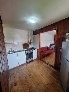 a kitchen with white cabinets and a red couch at Playas de Quintero in Quintero