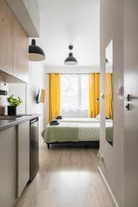 a bedroom with a bed and a window with yellow curtains at ADLER Room Suite in Łódź