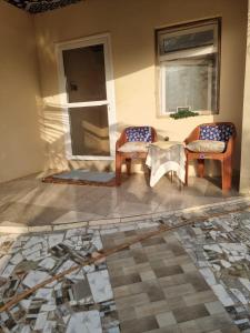 Exodus Eco Camping Lodge& Resturant في Tujering: فناء فيه كرسيين وطاولة ونافذة