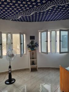 Exodus Eco Camping Lodge& Resturant في Tujering: غرفة ذات سقف ومروحة ونوافذ