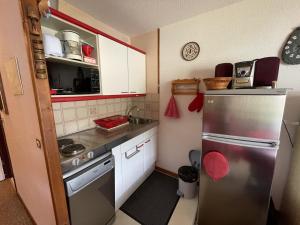 a small kitchen with a stainless steel refrigerator at Appartement 2 pièces Griou 52 in Le Lioran +5 photos