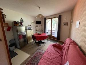 a kitchen with a table and a kitchen with a refrigerator at Appartement 2 pièces Griou 52 in Le Lioran