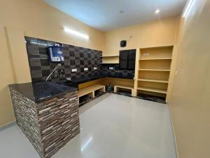 a kitchen with a counter with a tv and shelves at GYANi 1 in Tiruvannāmalai