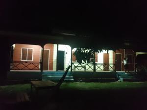 a row of houses at night with a fence at Anan guesthouse in Don Det