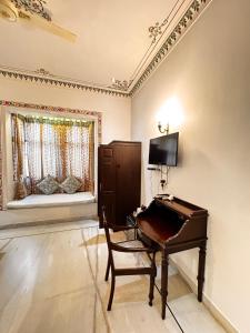 a room with a piano and a chair and a window at Hotel Boheda Palace - 1KM away from Lake Pichola in Udaipur