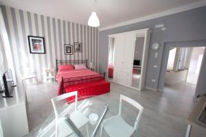 una camera con letto rosso e alcune sedie di Giualduomo B&B a SantʼAgata deʼ Goti