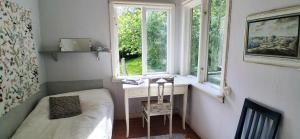 Charming house with kayaks, 300m from the sea on Orust SE09139 في Svineviken: غرفة نوم مع مكتب وسرير ونافذة