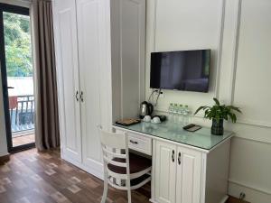 a room with a desk with a television and a chair at Lynh's Villa in Cat Ba