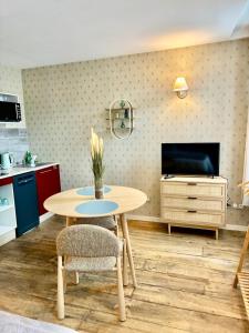 een eetkamer met een tafel en een tv bij Le Cocon de la Trinité T22 in Troyes
