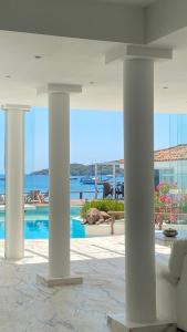 ein Raum mit Säulen und ein Swimmingpool mit Meerblick in der Unterkunft Villa Romana Búzios in Búzios