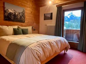 a bedroom with a large bed with a window at Haus Vallazza in Fulpmes