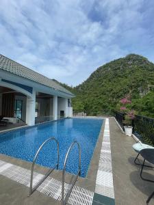 Lynh's Villa في كات با: مسبح في خلفية جبل