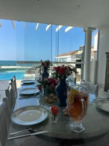 einen langen Tisch mit Tellern und Blumen darauf in der Unterkunft Villa Romana Búzios in Búzios