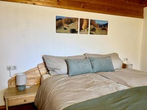 a bed in a bedroom with three pictures on the wall at Haus Vallazza in Fulpmes