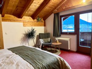 a bedroom with a bed and a chair and a window at Haus Vallazza in Fulpmes +8 photos