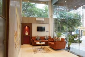 a lobby with couches and a tv in a building at Aarambh By The Sky Imperial Indore in Indore
