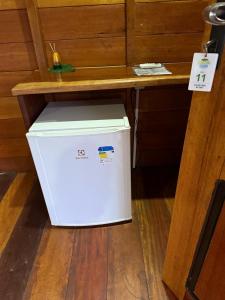 马瑙斯Amazon Tucuna Resort的木桌下有一台白色冰箱