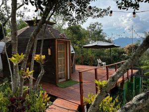 a wooden deck with a cabin with an umbrella at Prana Hills in Estación El Salto