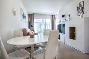 a white dining room with a white table and chairs at Intempo by Holuxe - 034 - 3rd floor in Benidorm