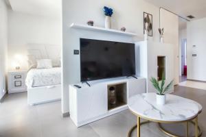 a white living room with a large flat screen tv at Intempo by Holuxe - 034 - 3rd floor in Benidorm +16 photos