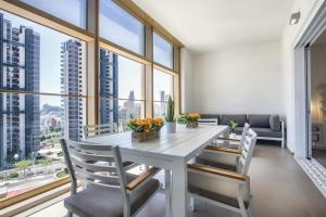 a dining room with a table and chairs and large windows at Intempo by Holuxe - 034 - 3rd floor in Benidorm
