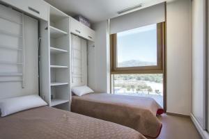 two beds in a room with a window at Intempo by Holuxe - 034 - 3rd floor in Benidorm