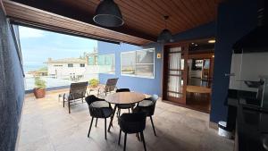 a dining room with a table and chairs on a patio at Pousada Gamboa estações in Garopaba