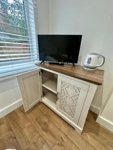a desk with a television on top of it at Kettering Railway Lodge in Northamtonshire