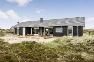 une maison noire avec une terrasse sur la plage dans l'établissement 899-Snedsted-Somaerkevej-76-B, à Snedsted