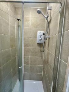 a shower with a shower head in a bathroom at Kettering Railway Lodge in Kettering +7 photos