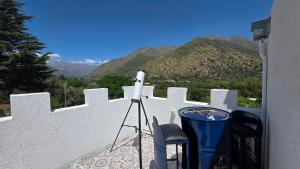 Oceana Suites San José de Maipo في إل كانيلو: كاميرا وكرسيان على شرفة مطلة على الجبال