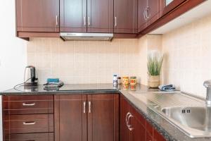 a kitchen with wooden cabinets and a sink at ERAL Apart-Hotel & Penthouse in Sarandë +163 photos