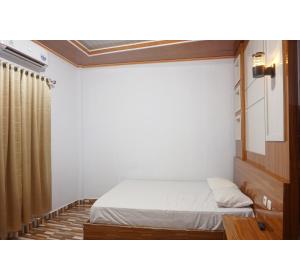 a small bedroom with a bed and a shower at Hotel O Pondom Danu 77 in Kendari