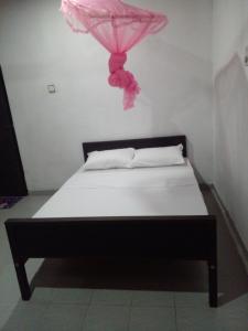 a bedroom with a bed with a pink umbrella on it at chula,s Home Stay in Matara