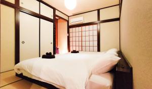 una camera da letto con un grande letto bianco con una finestra di 美-yahiro- a Tokyo