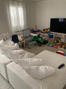 un salon avec un canapé blanc et une télévision dans l'établissement Maison de vacances et de paix, à Monteux