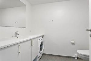 baño blanco con lavadora y aseo en 781-Thisted-Havstokken-28-A, en Thisted
