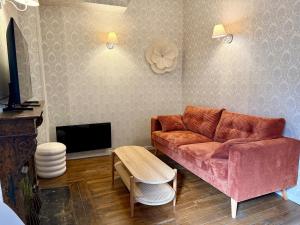 een woonkamer met een bank en een tv bij La Grande escapade T12 in Troyes