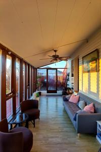 a living room with couches and chairs and a ceiling at Laufás Guesthouse in Hellissandur +34 photos
