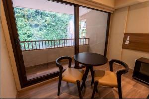 Habitación con mesa, 2 sillas y ventana en Termales Santa Rosa De Cabal, en Santa Rosa de Cabal