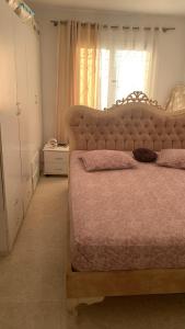 um quarto com uma cama grande e uma janela em App corniche hammamet em Hammamet