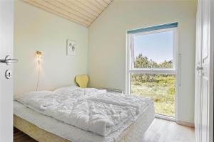 een witte slaapkamer met een bed en een raam bij 969-Thisted-Klitstien-50 in Torsted