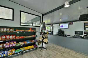 a grocery store aisle with a person standing at the counter at SleepOver Orpen Gate in Acornhoek +118 photos