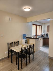 a kitchen and dining room with a table and chairs at Casaroca Stylish 2br in Nakuru +2 photos