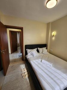 a bedroom with a large bed with shoes on the floor at Casaroca Stylish 2br in Nakuru