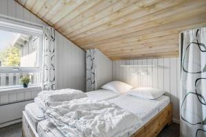 a bed in a room with a wooden ceiling at 1052-Thisted-Bavnbak-50 in Torsted