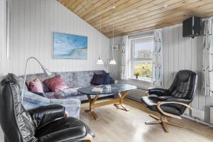 a living room with a couch and a table and chairs at 1052-Thisted-Bavnbak-50 in Torsted