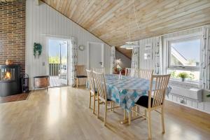 a dining room with a table and chairs and a fireplace at 1052-Thisted-Bavnbak-50 in Torsted +16 photos
