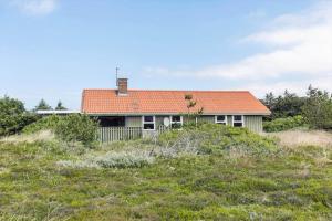 a house with an orange roof on top of a field at 1052-Thisted-Bavnbak-50 in Torsted