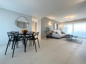 a living room with a table and chairs and a couch at Luxury Sea View - PANORAMA MAR- PUNTA PRIMA by GrupoQuattro in Punta Prima